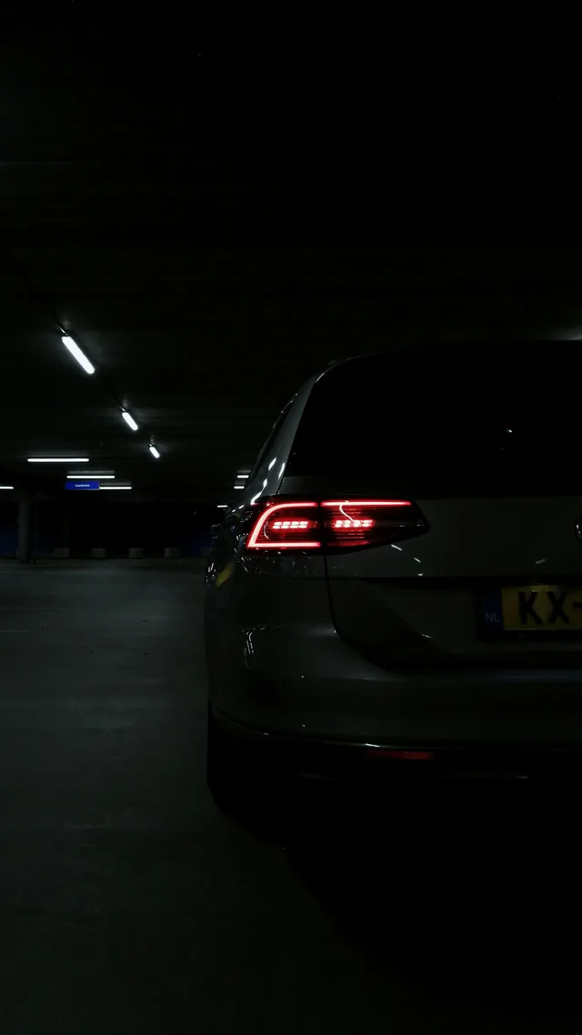 Rear lights of a dark car in an underground garage